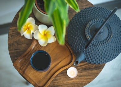 Relaxing teapot scene at Yoganic Thai Spa and Massage in London, England, GB with flowers and candle.