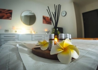 Relaxing massage room at Yoganic Thai Spa and Massage in London, England, GB with aroma oils and flowers.