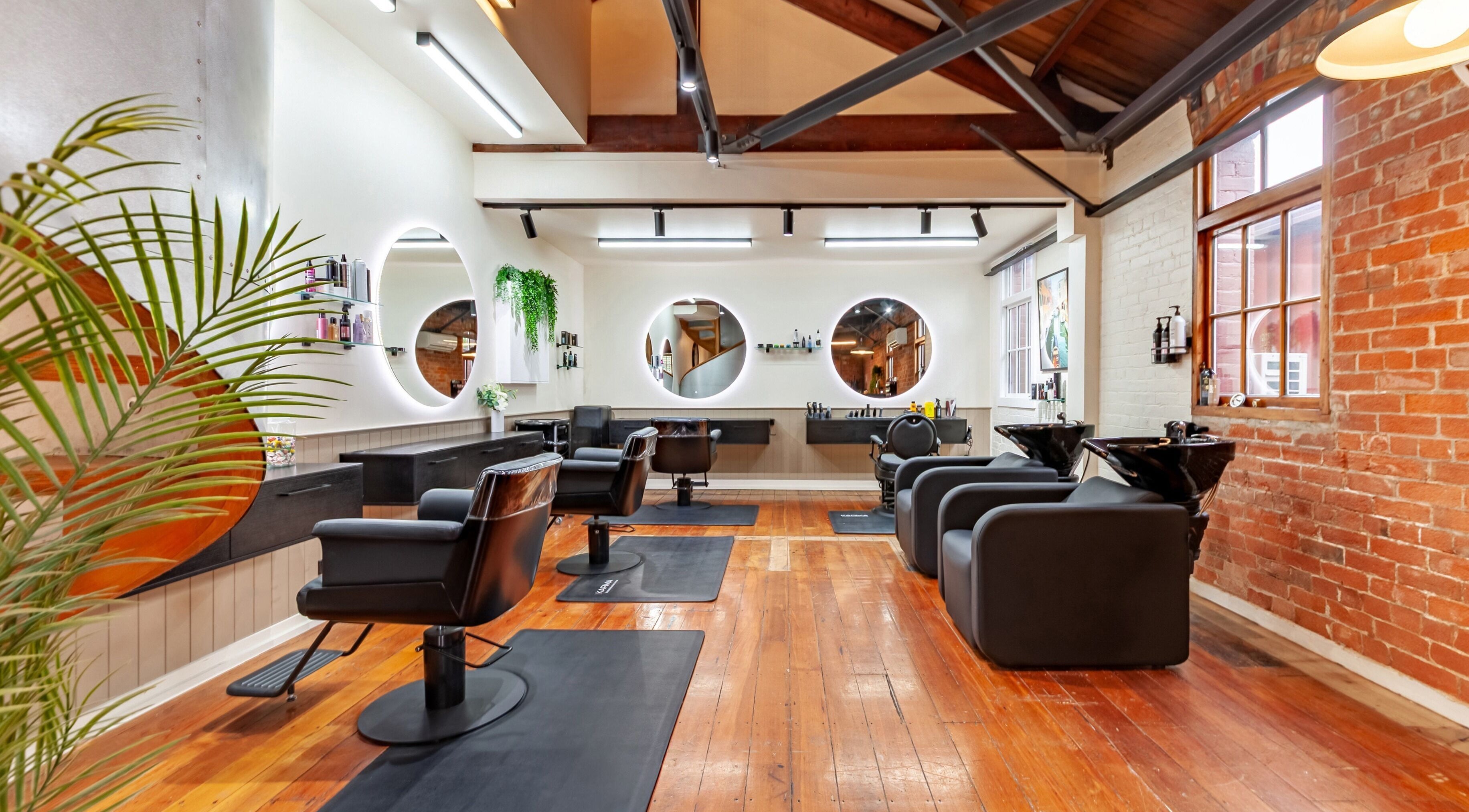 Modern salon interior at Barnet Fair, Christchurch, Canterbury, NZ with stylish chairs and round mirrors.