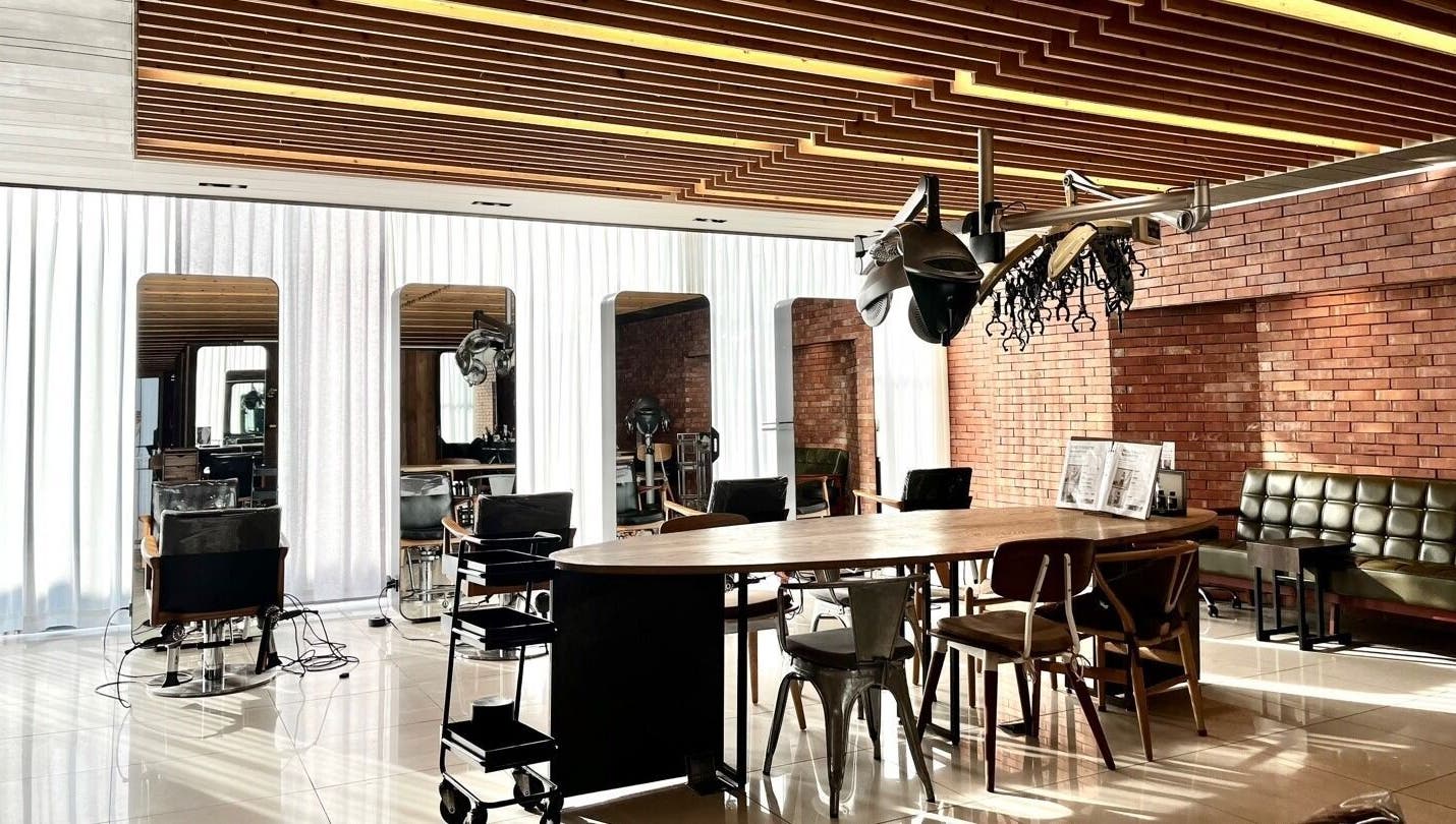 Modern interior of 준오헤어 명동4호점 Juno Hair Myungdong 4, Seoul, featuring stylish seating in a sunlit space.