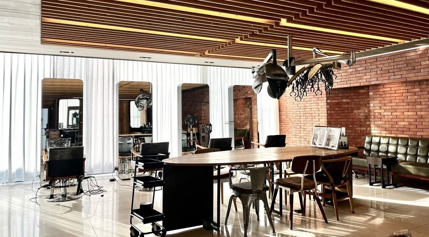 Modern interior of 준오헤어 명동4호점 Juno Hair Myungdong 4, Seoul, featuring stylish seating in a sunlit space.