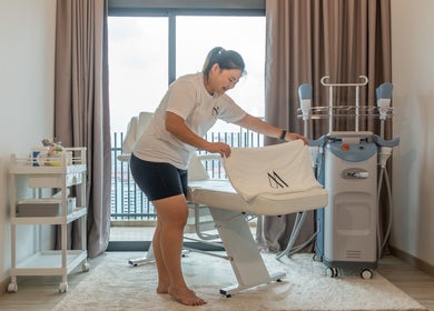 A staff member preparing a treatment room at AURA J Gateway Studio, Singapore, Singapore, SG.