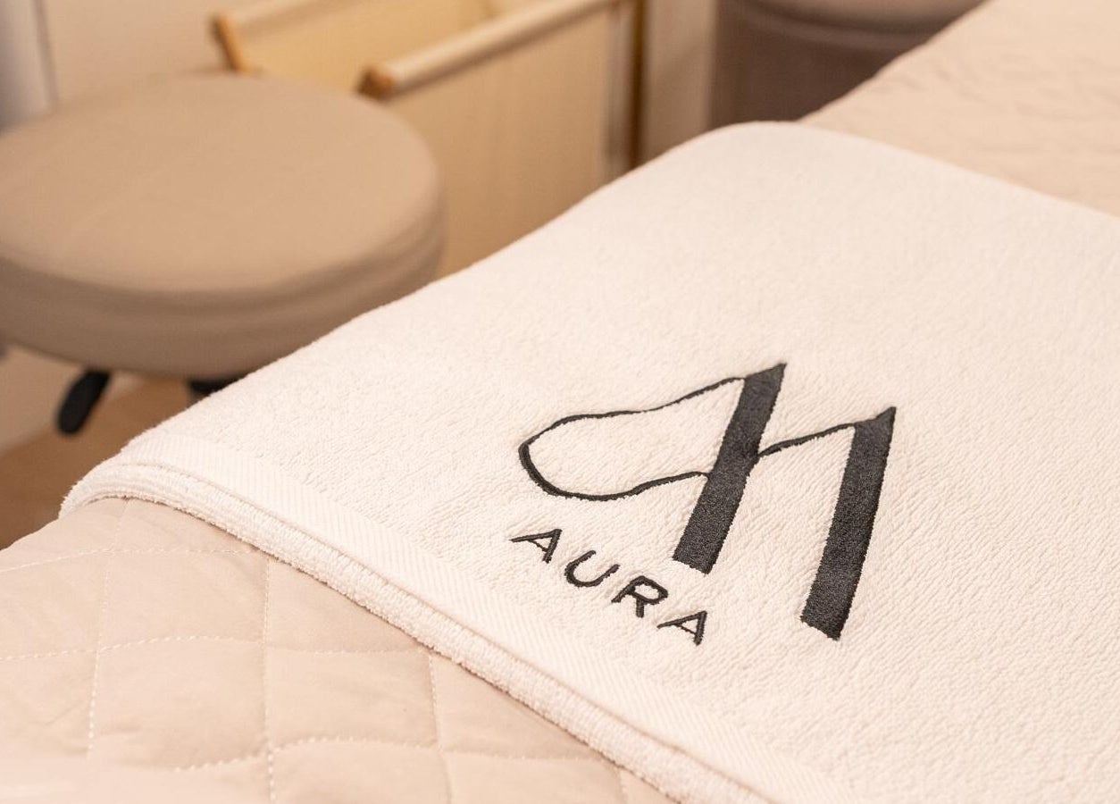 AURA Woodleigh Studio massage bed with branded towel in Singapore, Singapore, SG, enhancing relaxation ambiance.
