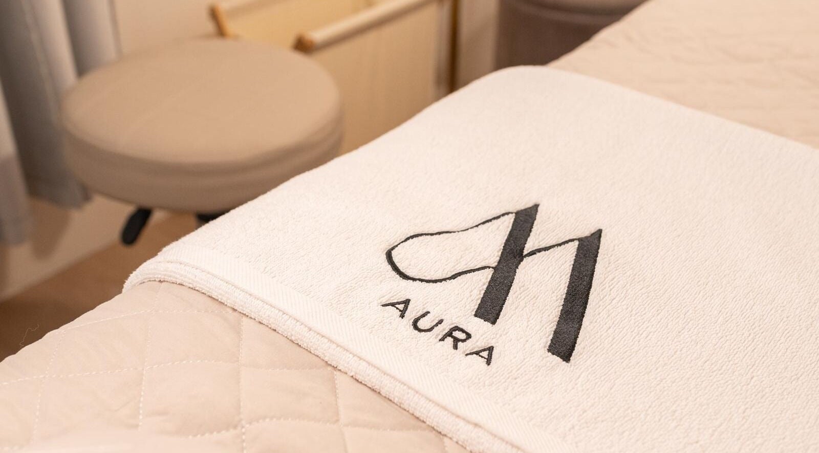 AURA Woodleigh Studio massage bed with branded towel in Singapore, Singapore, SG, enhancing relaxation ambiance.