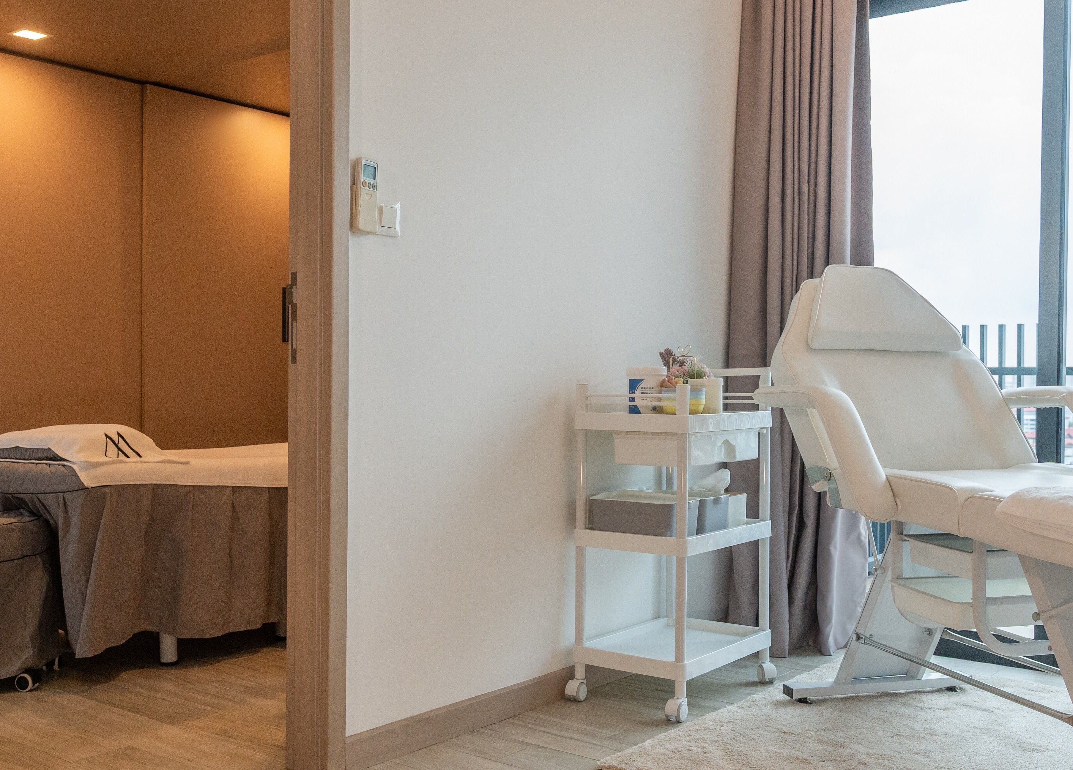 Relaxing treatment room at AURA Jurong Studio, Singapore, Singapore, SG with a massage bed and chair.