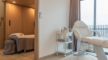 Relaxing treatment room at AURA Jurong Studio, Singapore, Singapore, SG with a massage bed and chair.