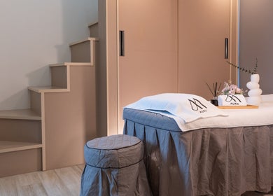 Relaxing massage table at AURA Jurong Studio in Singapore, SG with soothing decor and soft lighting.