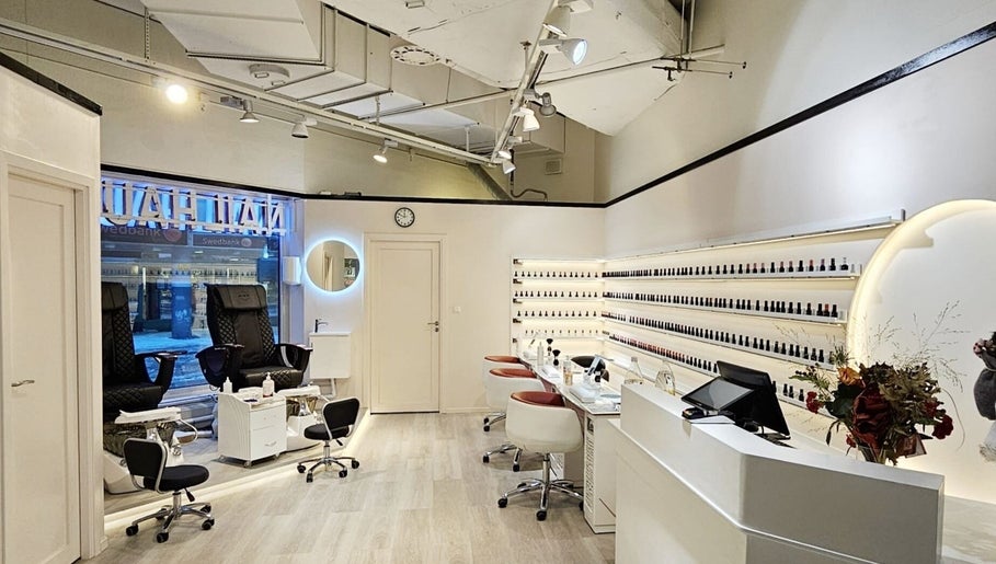 Interiören av Nail Haus Luleå i Luleå, Norrbottens Län med eleganta nagelstationer och flaska hyllor.
