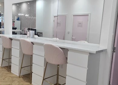 Elegant makeup station at The Salon Sanctuary, Liverpool, England, GB, featuring pink chairs and mirrors.