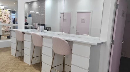 Elegant styling stations at The Salon Sanctuary, Liverpool, England, GB, showcasing pink chairs and mirror decor.
