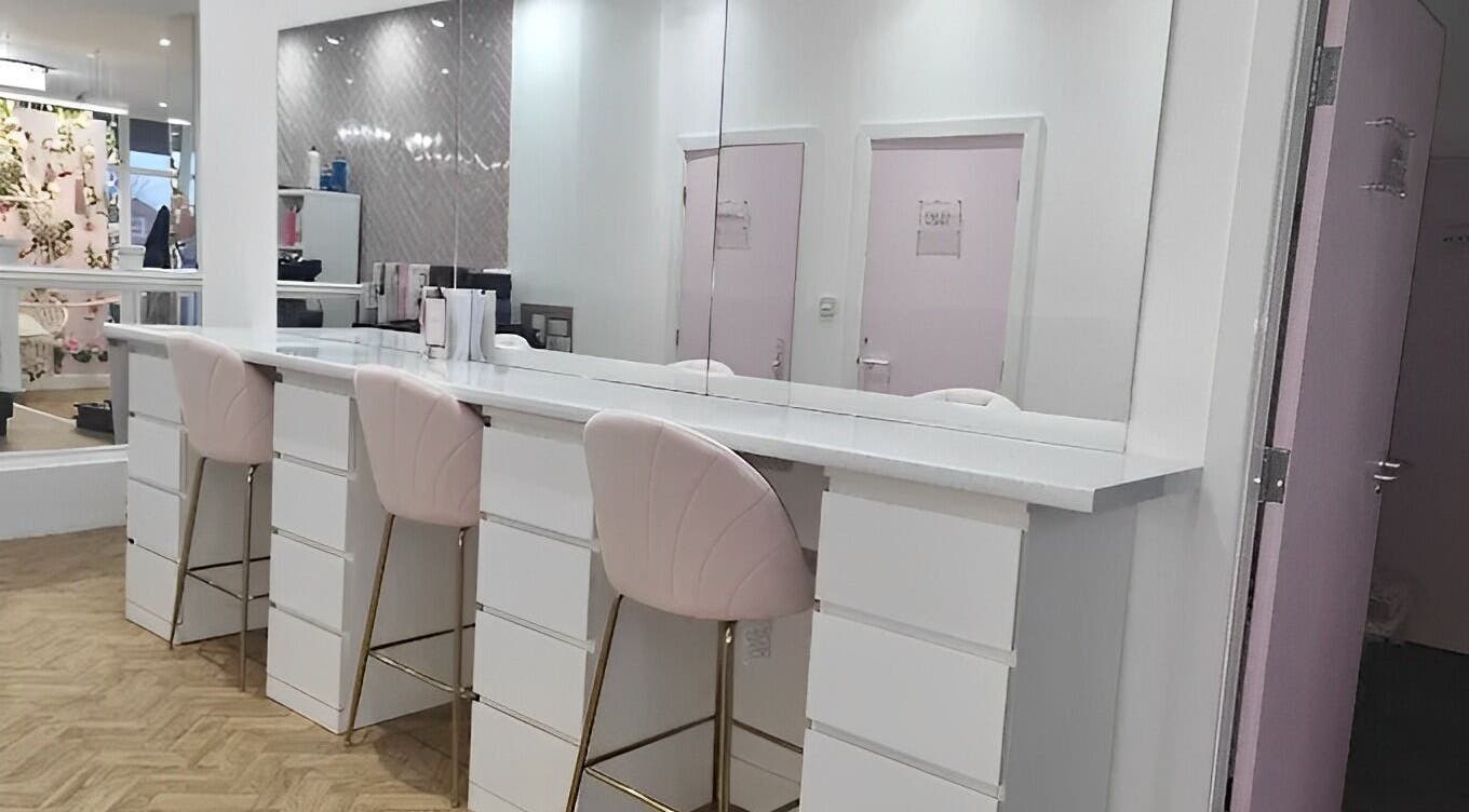 Elegant styling stations at The Salon Sanctuary, Liverpool, England, GB, showcasing pink chairs and mirror decor.