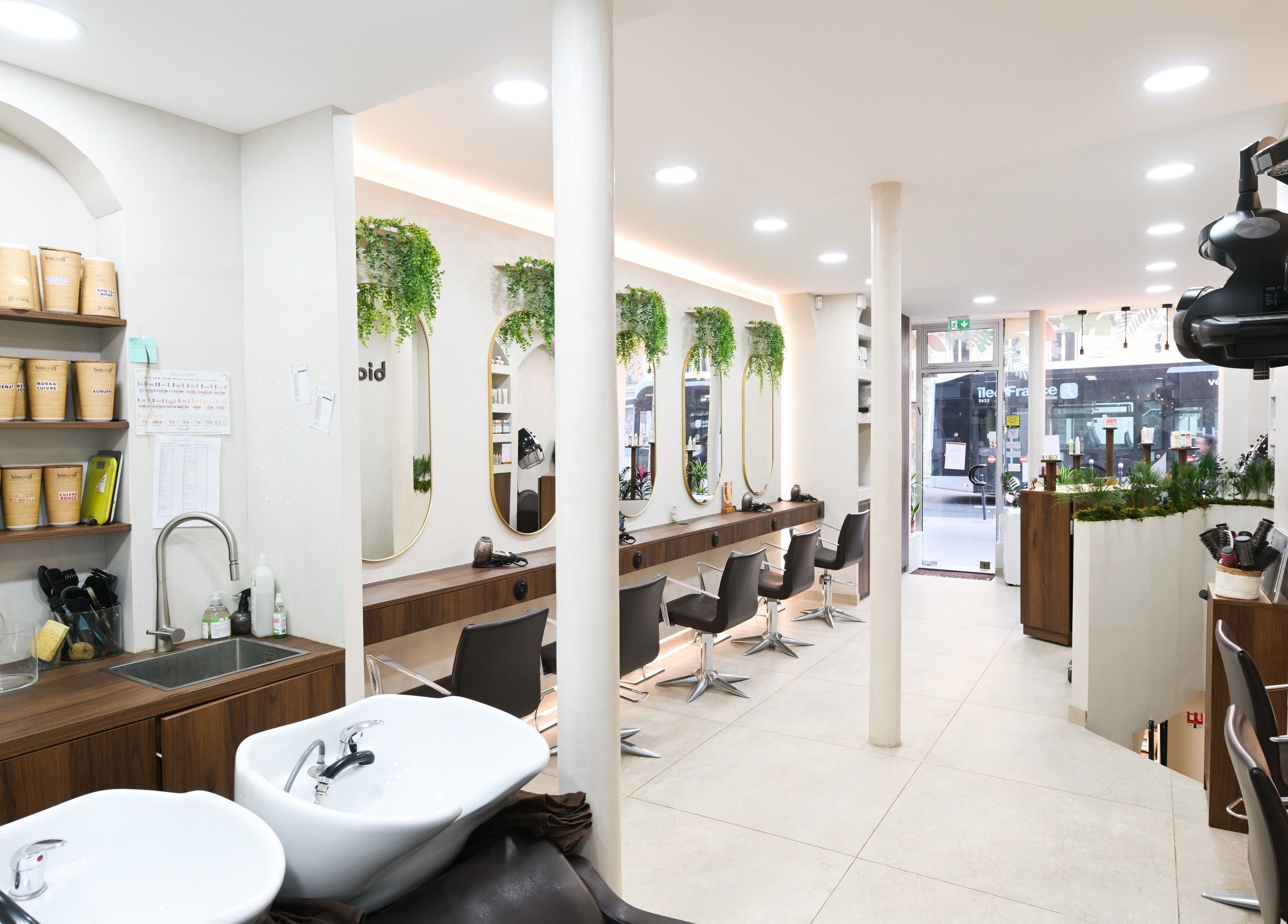 Intérieur élégant du salon Biocoiff à Paris, Île-de-France, FR avec miroirs et plantes vertes.