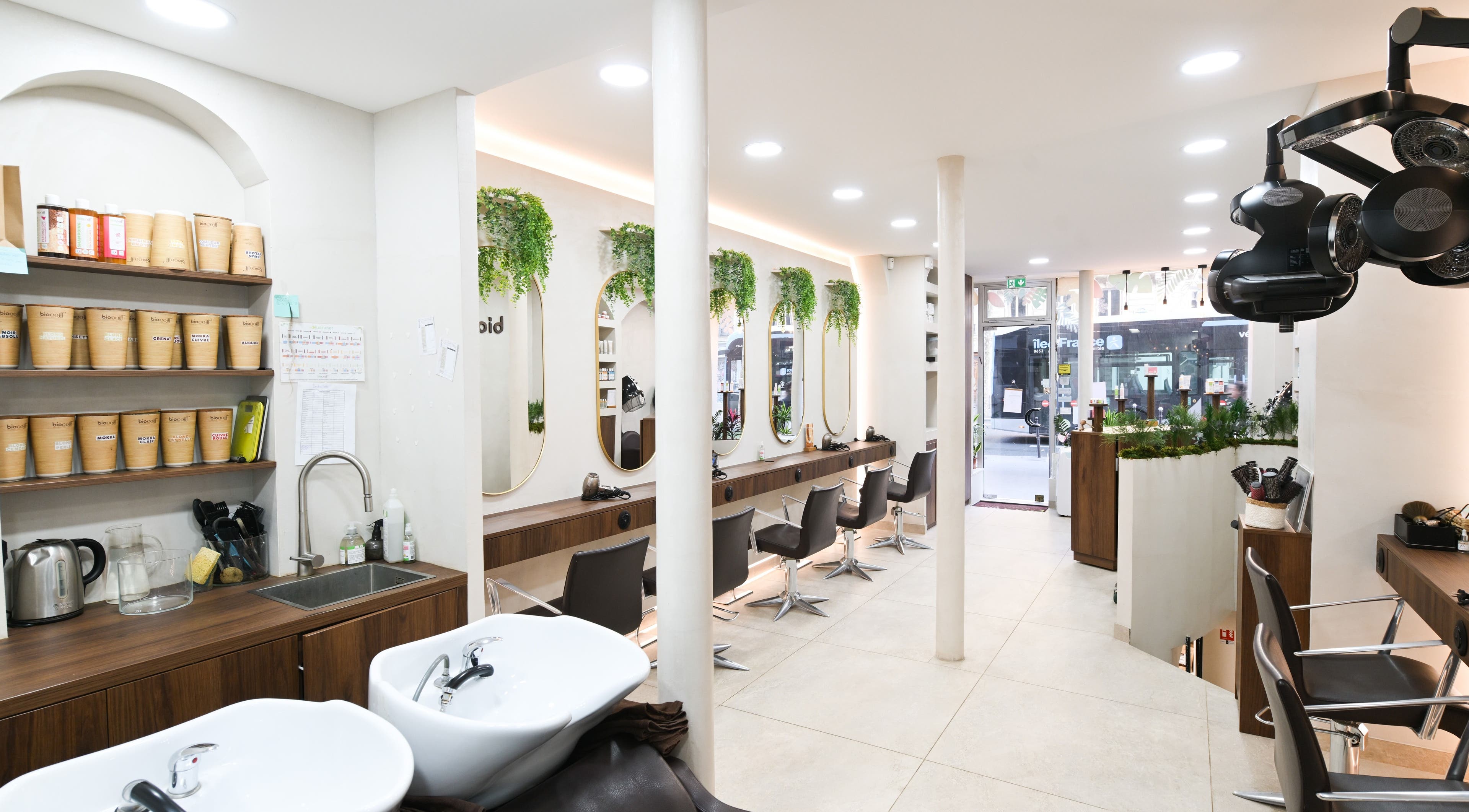 Intérieur élégant du salon Biocoiff à Paris, Île-de-France, FR avec miroirs et plantes vertes.