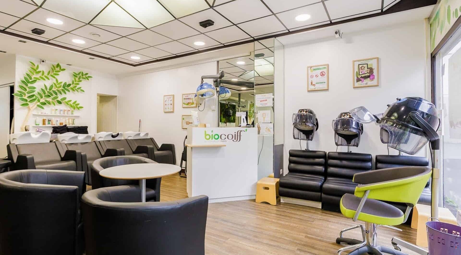 Intérieur moderne de Biocoiff Jeanne d'Arc à Paris, Île-de-France, FR avec sièges confortables et séchoirs.