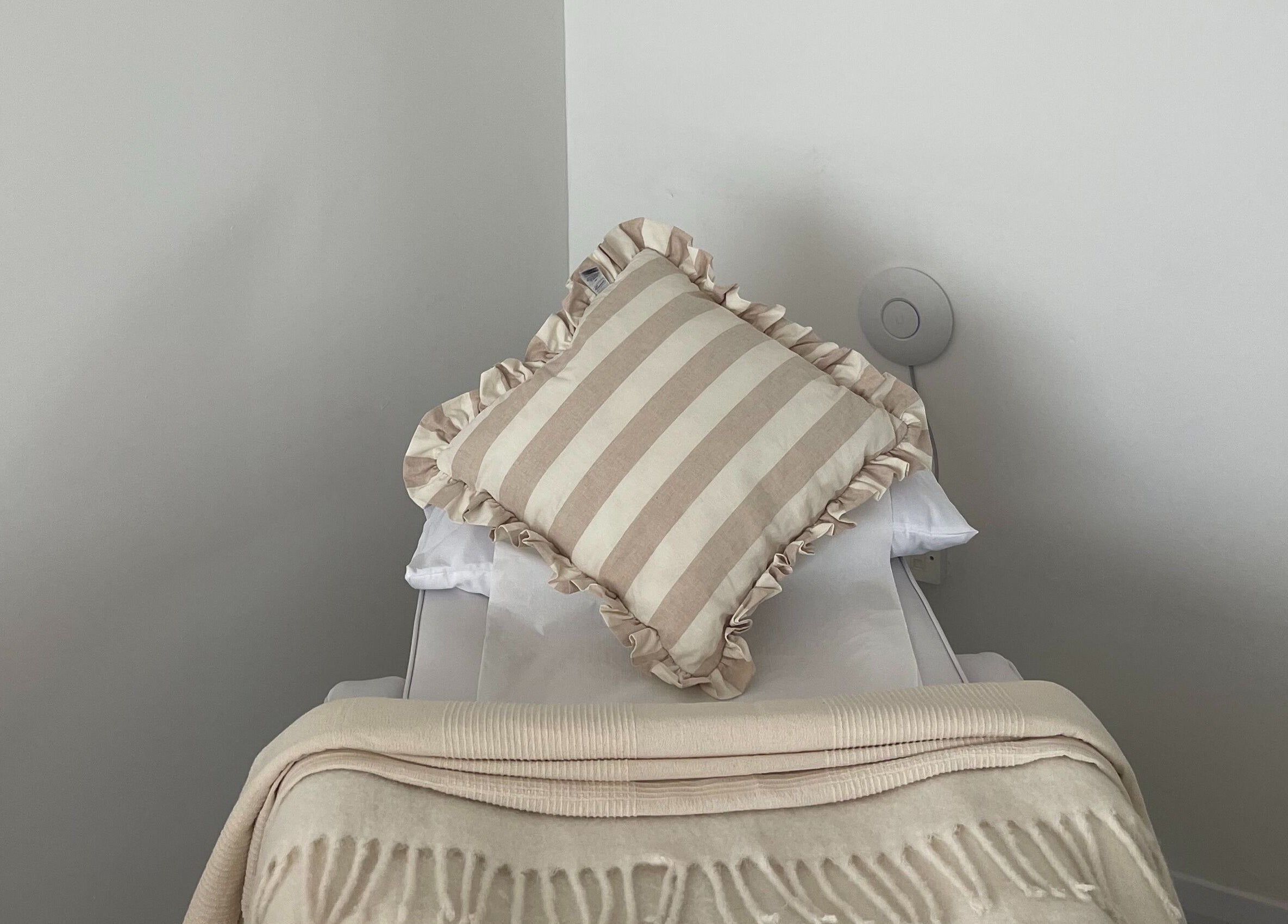 Cozy treatment bed at Leah Jane Beauty and Aesthetics in Rochester, England, GB, featuring a striped pillow.