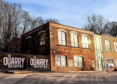 Naomi Clarke PT-The Quarry Health and Fitness in Backwell, England. A rustic brick building amid trees.