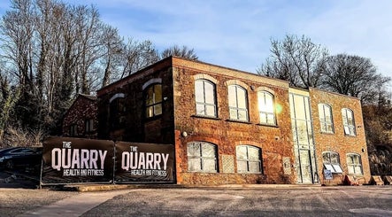 Naomi Clarke PT-The Quarry Health and Fitness in Backwell, England. A rustic brick building amid trees.