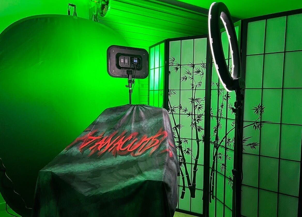 Tanacuts Melbourne, Victoria, AU: Chic salon space with green lighting and bamboo decor for serene beauty experiences.