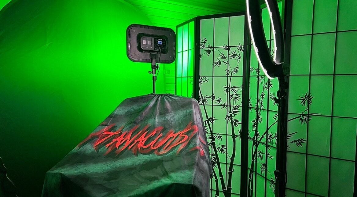 Tanacuts Melbourne, Victoria, AU: Chic salon space with green lighting and bamboo decor for serene beauty experiences.