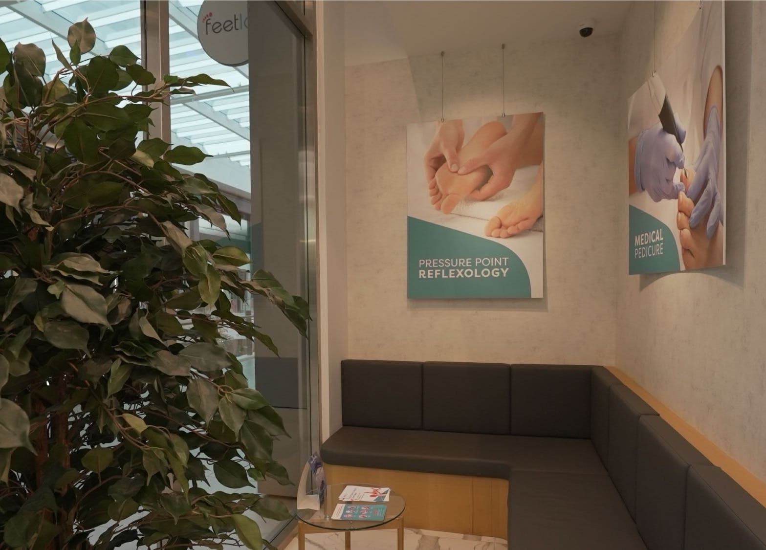 Relaxing seating area at Feetlab Podiatry L.L.C - Dubai Hills Mall, Dubai, AE with reflexology posters.