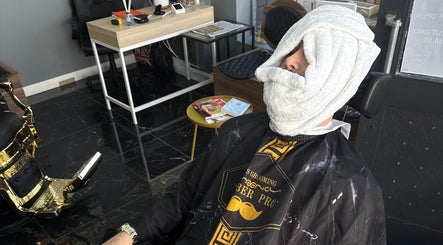 Client enjoying facial towel treatment at Epic barber Woking, located in Woking, England, GB.
