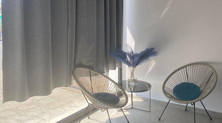 Γωνιά αναμονής στο El Encanto Nail Studio, Λακατάμια, Λευκωσία, CY με μοντέρνες καρέκλες και φυτά.