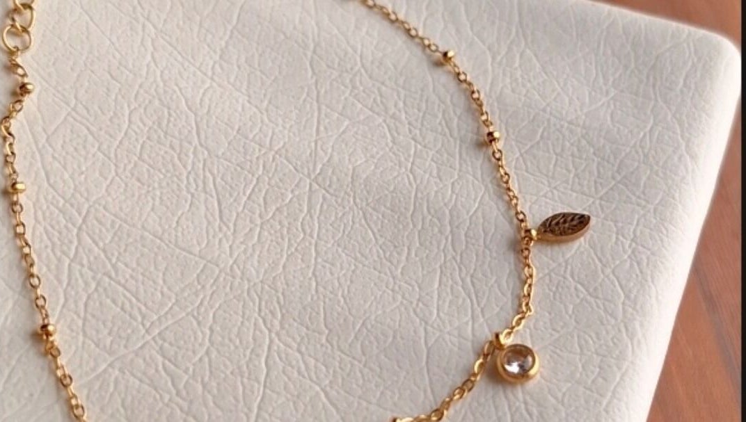 Delicate gold chain bracelet with leaf charm, available at nail art, Tehran, IR.