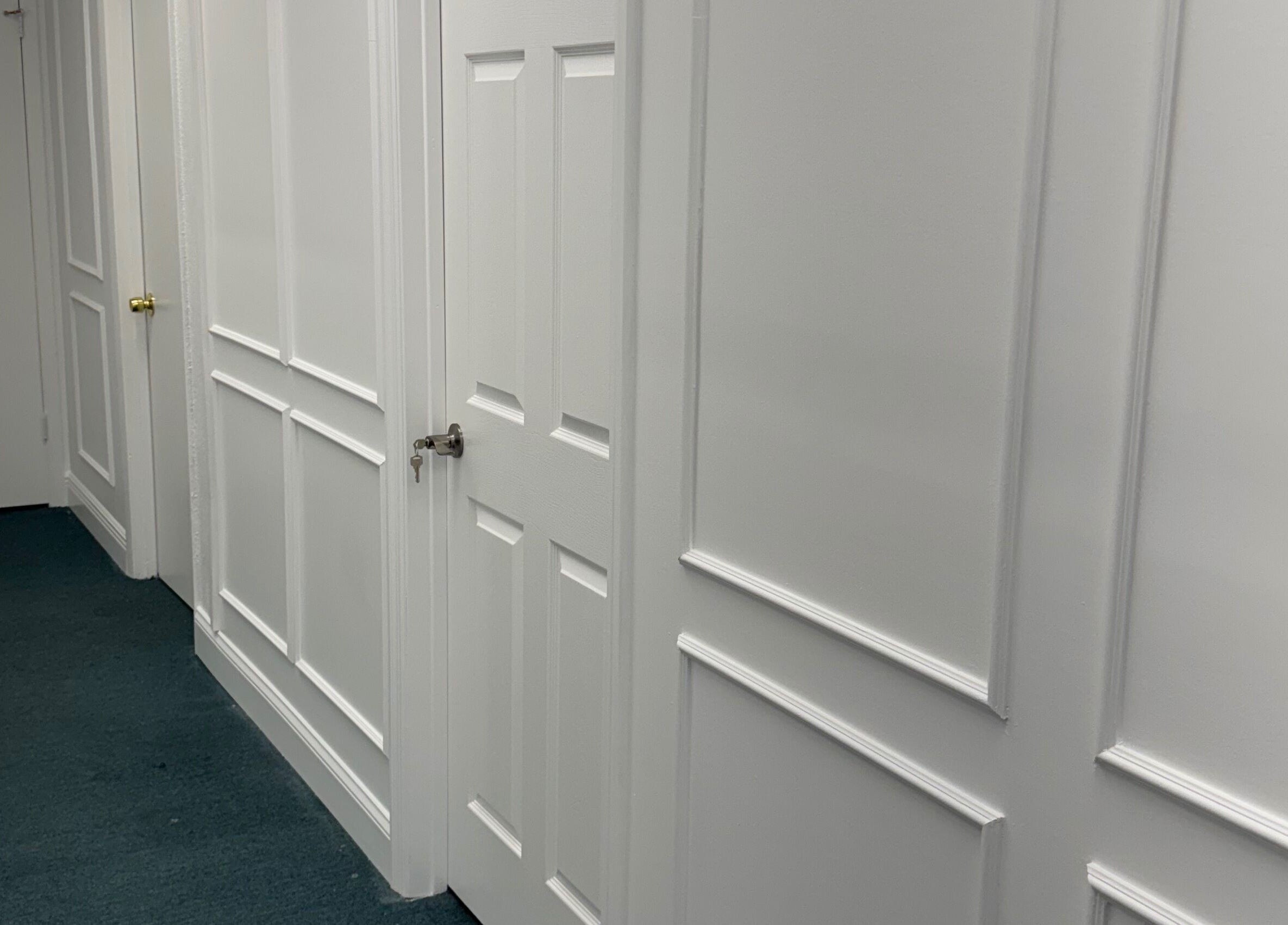 A pristine white hallway at iSugaring, featuring elegant panel doors in Seminole, Florida, US.