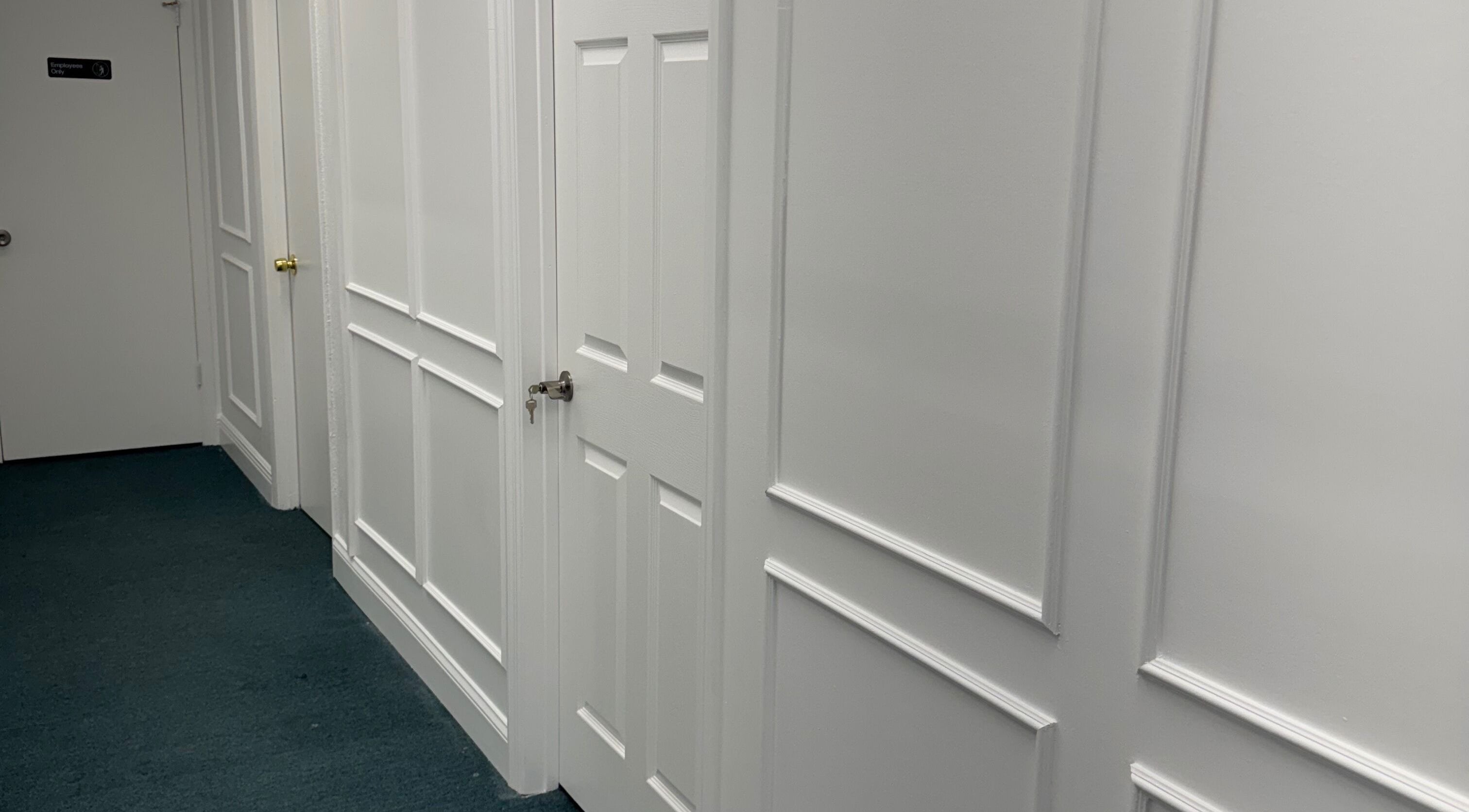 A pristine white hallway at iSugaring, featuring elegant panel doors in Seminole, Florida, US.