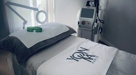 Spa treatment room at Miss Marie’s, Brooklyn, Nova Scotia, CA, featuring laser equipment and cozy bedding.
