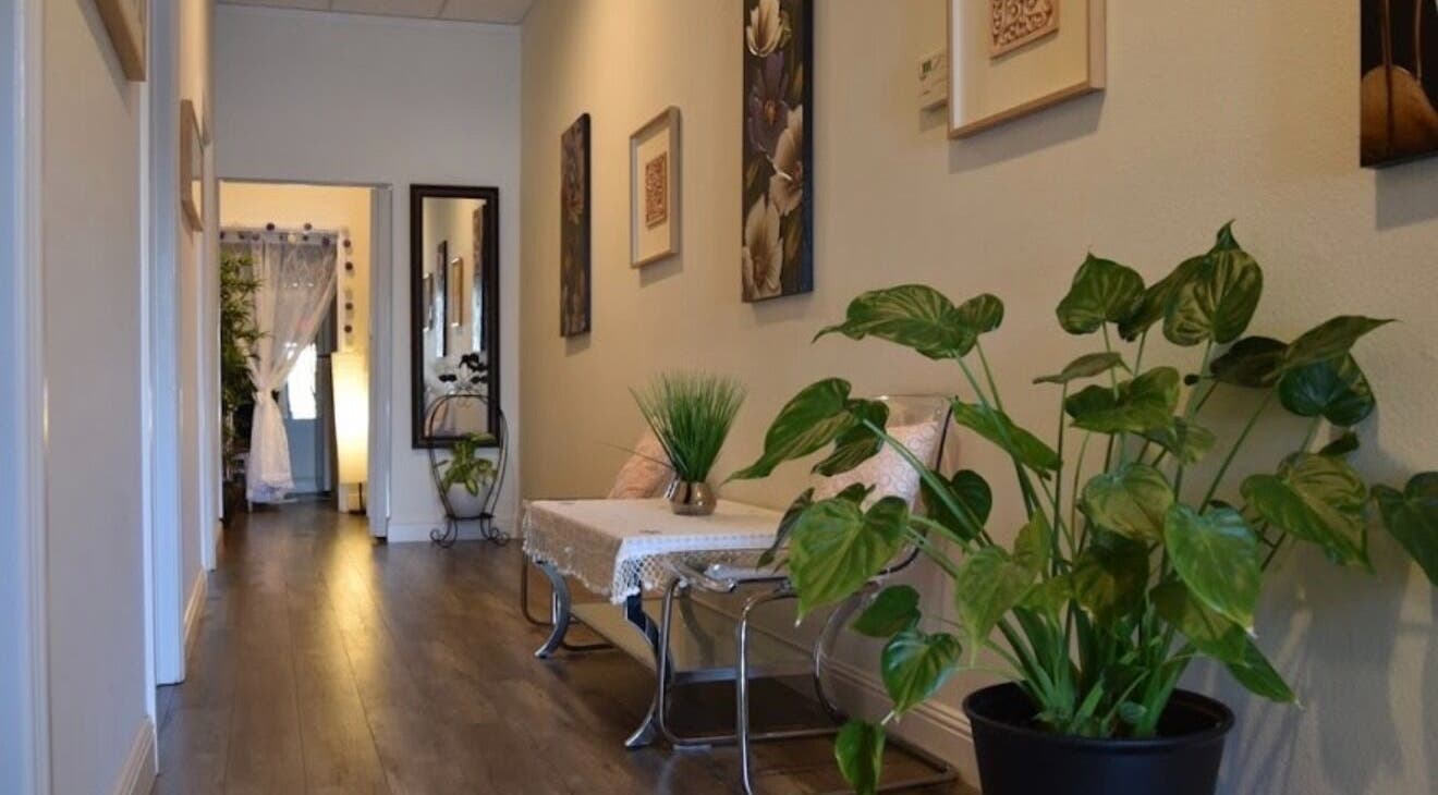 Tranquil hallway at Canoga Park Massage, Los Angeles, California, US, with plants and elegant decor.