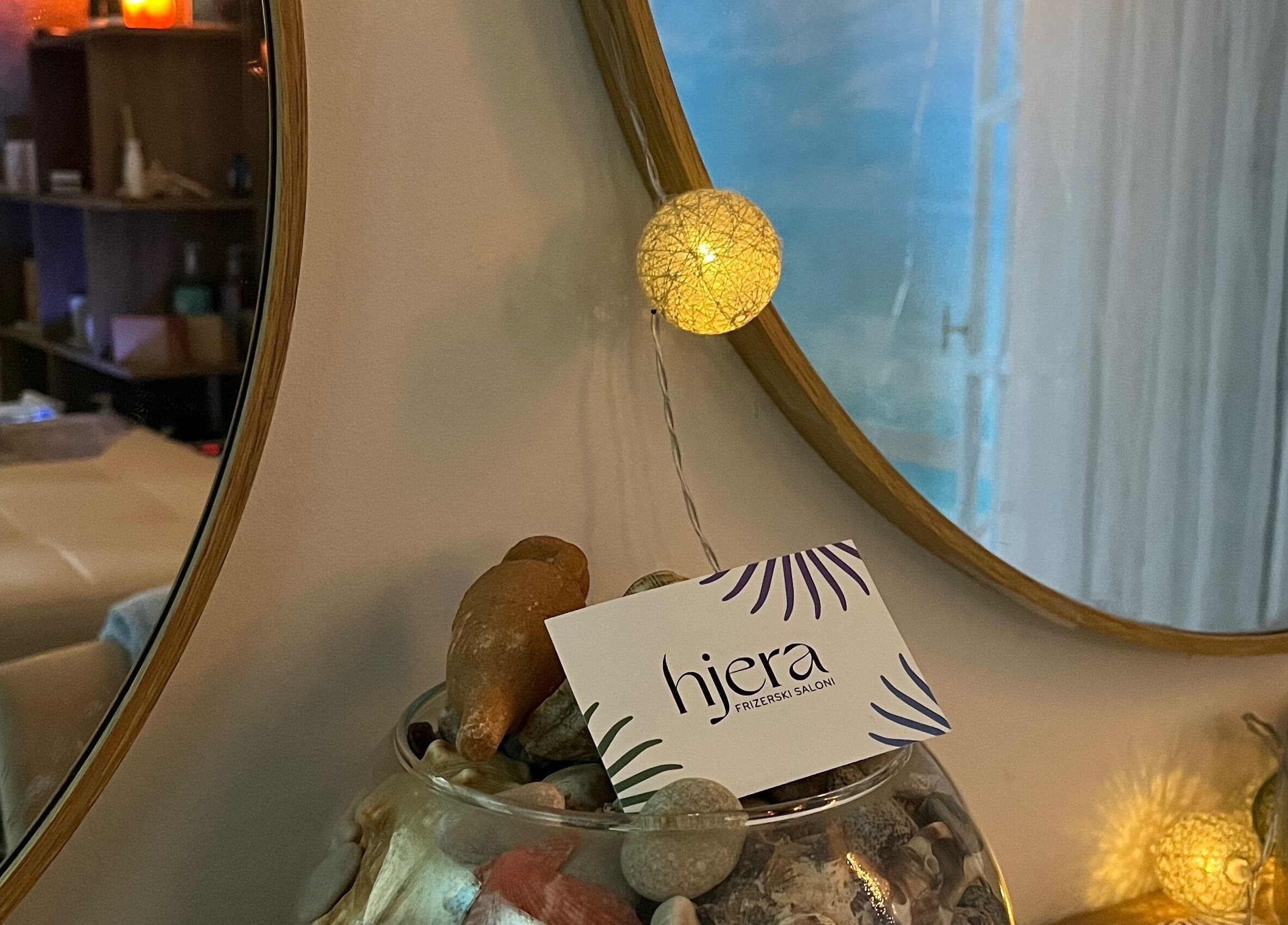 Calming decor with seashells and Hjera Studio & Spa card in Beograd, RS room mirror reflection.