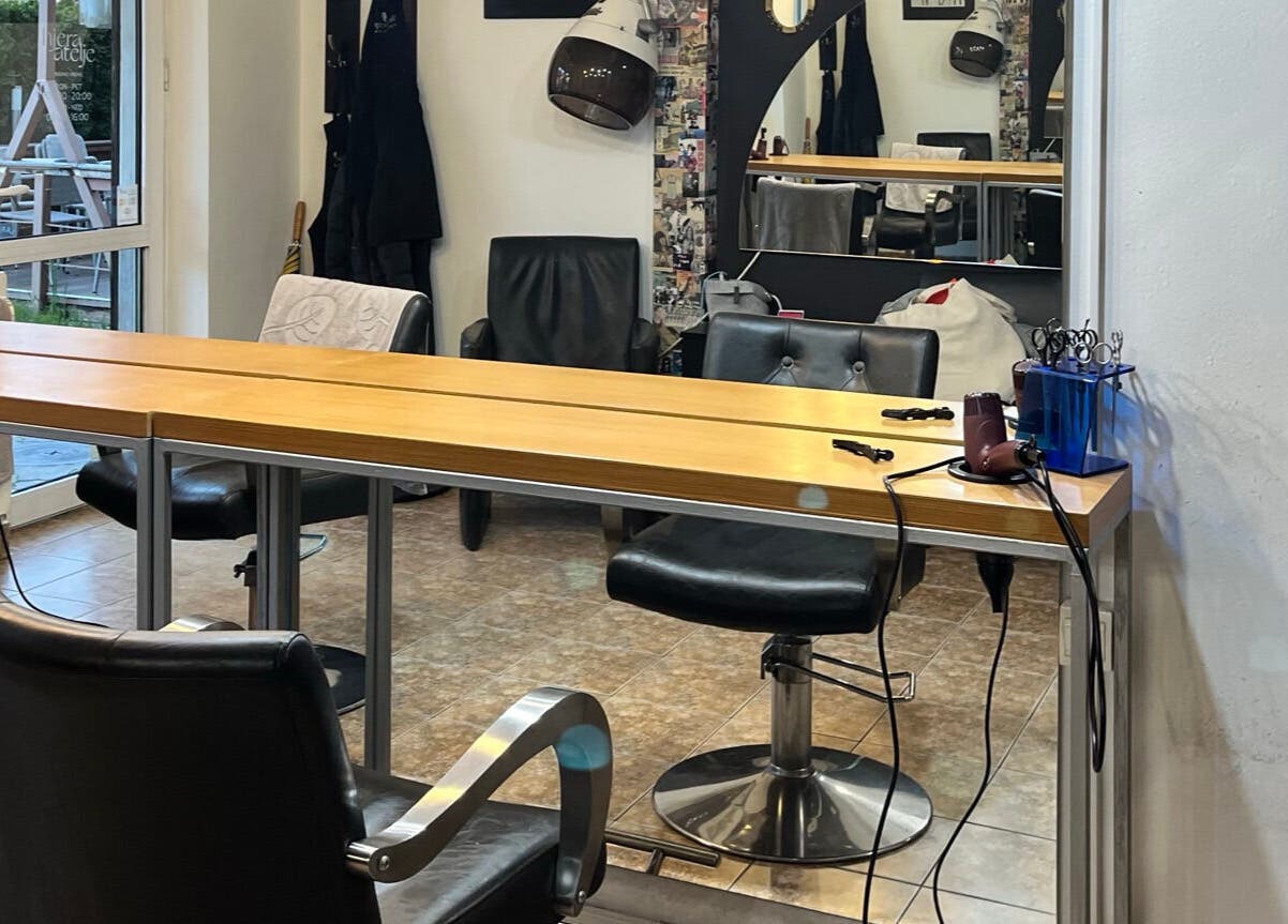 Modern salon interior at Hjera Atelje in Beograd, RS showcasing chairs, styling tools, and elegant decor.