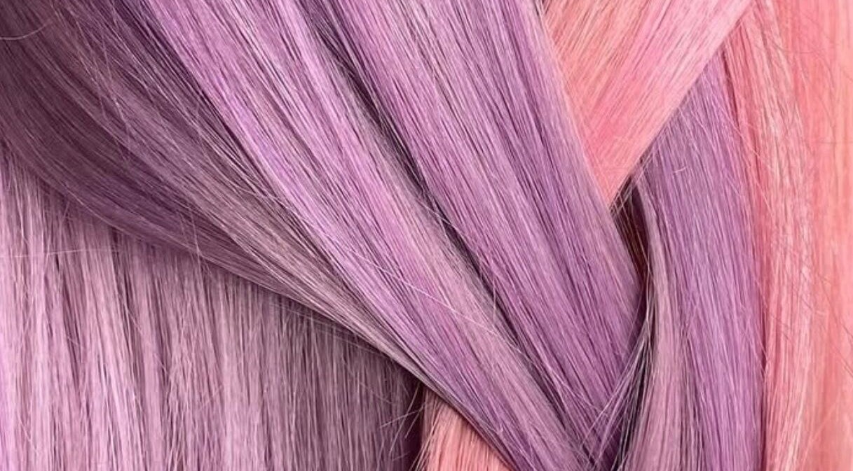 Vibrant purple and pink hair strands at EMWHAIR, Newport Pagnell, England, GB, showcasing modern dyeing techniques.