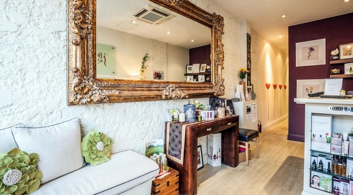 Elegant reception area at Sacred Lotus, London, England, GB with ornate mirror and soothing decor.