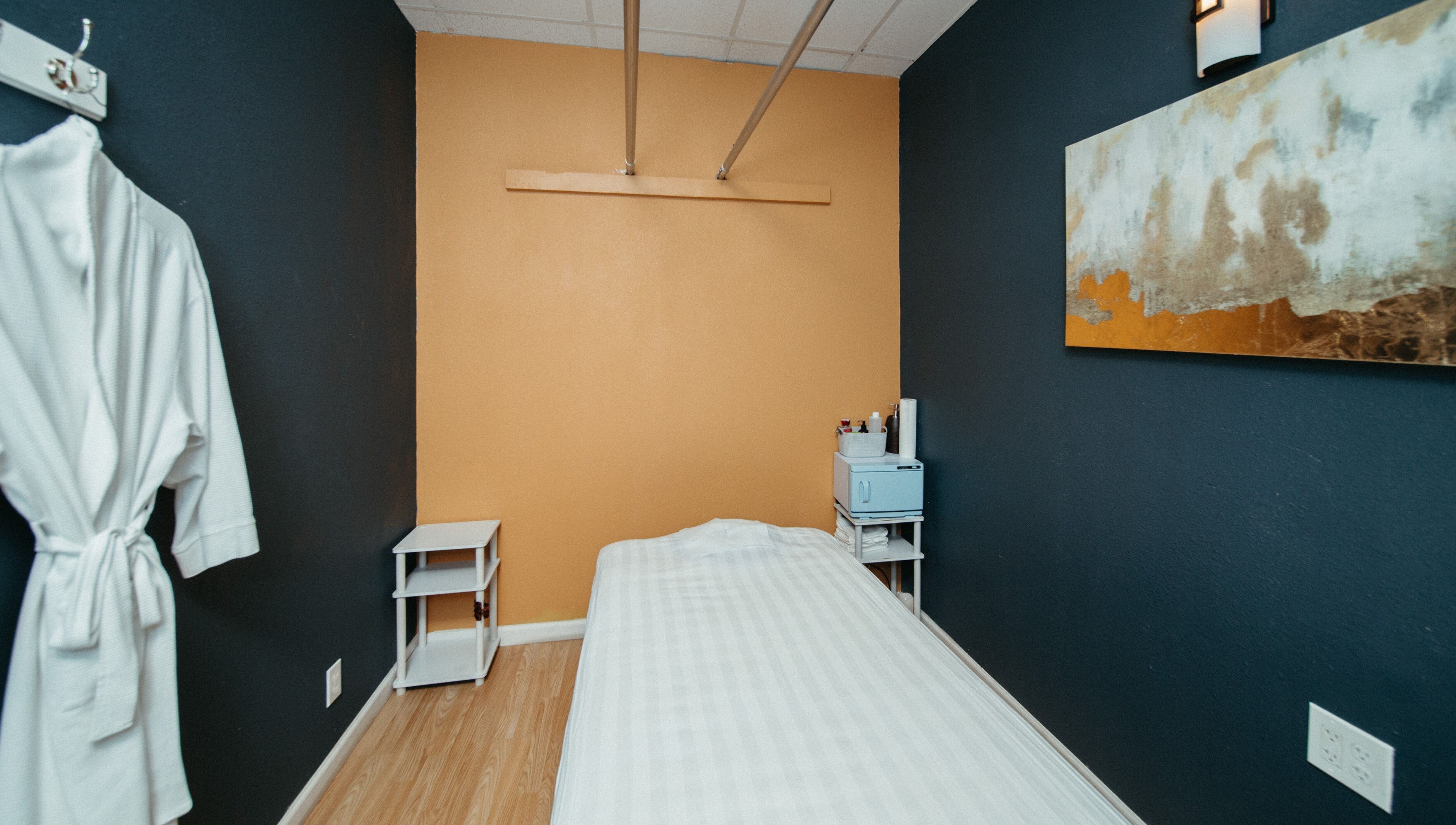 A serene massage room at Oak Tree Massage Oak Lawn in Dallas, Texas, US, featuring a neatly made bed.