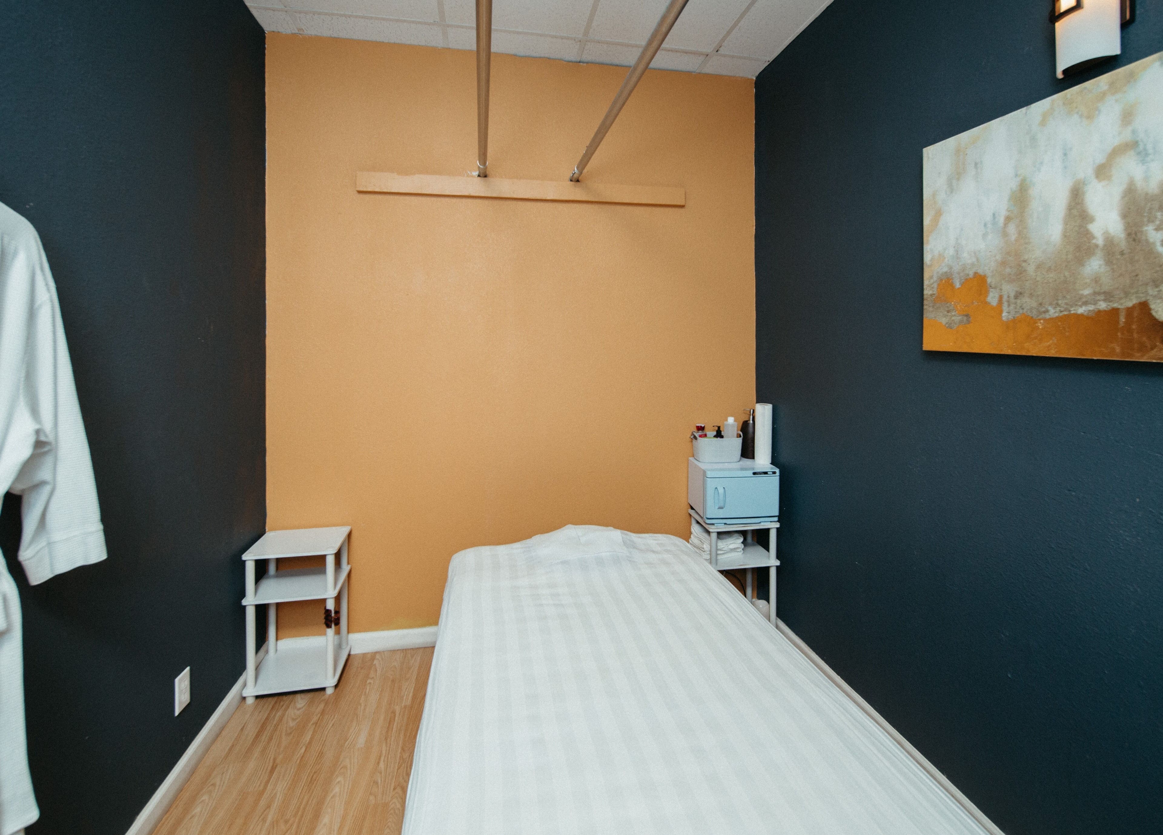 A serene massage room at Oak Tree Massage Oak Lawn in Dallas, Texas, US, featuring a neatly made bed.