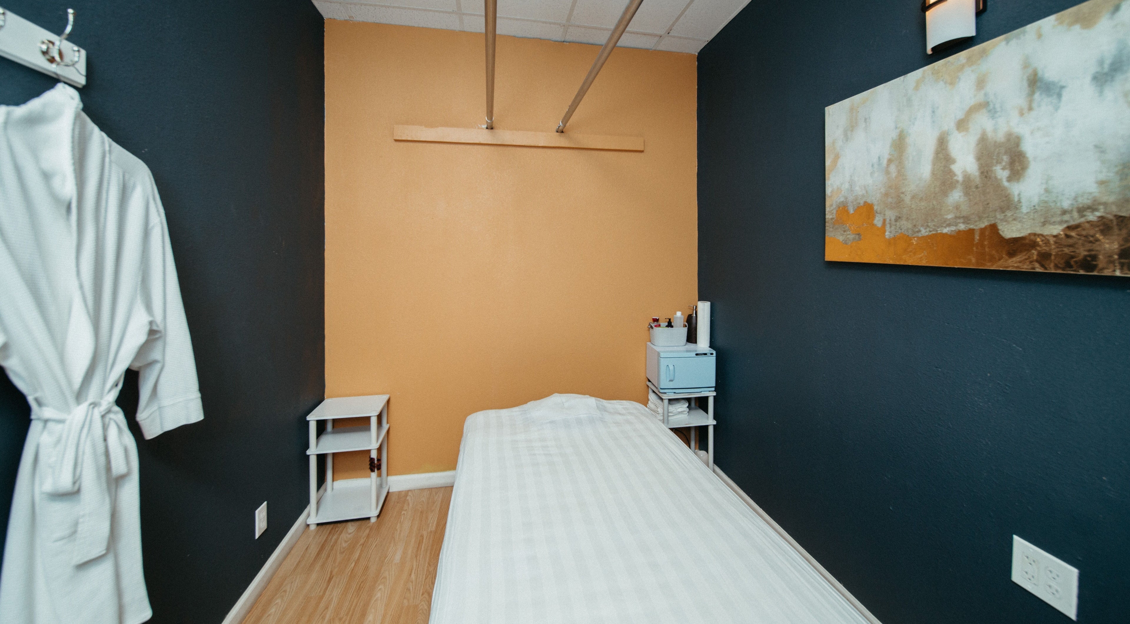 A serene massage room at Oak Tree Massage Oak Lawn in Dallas, Texas, US, featuring a neatly made bed.