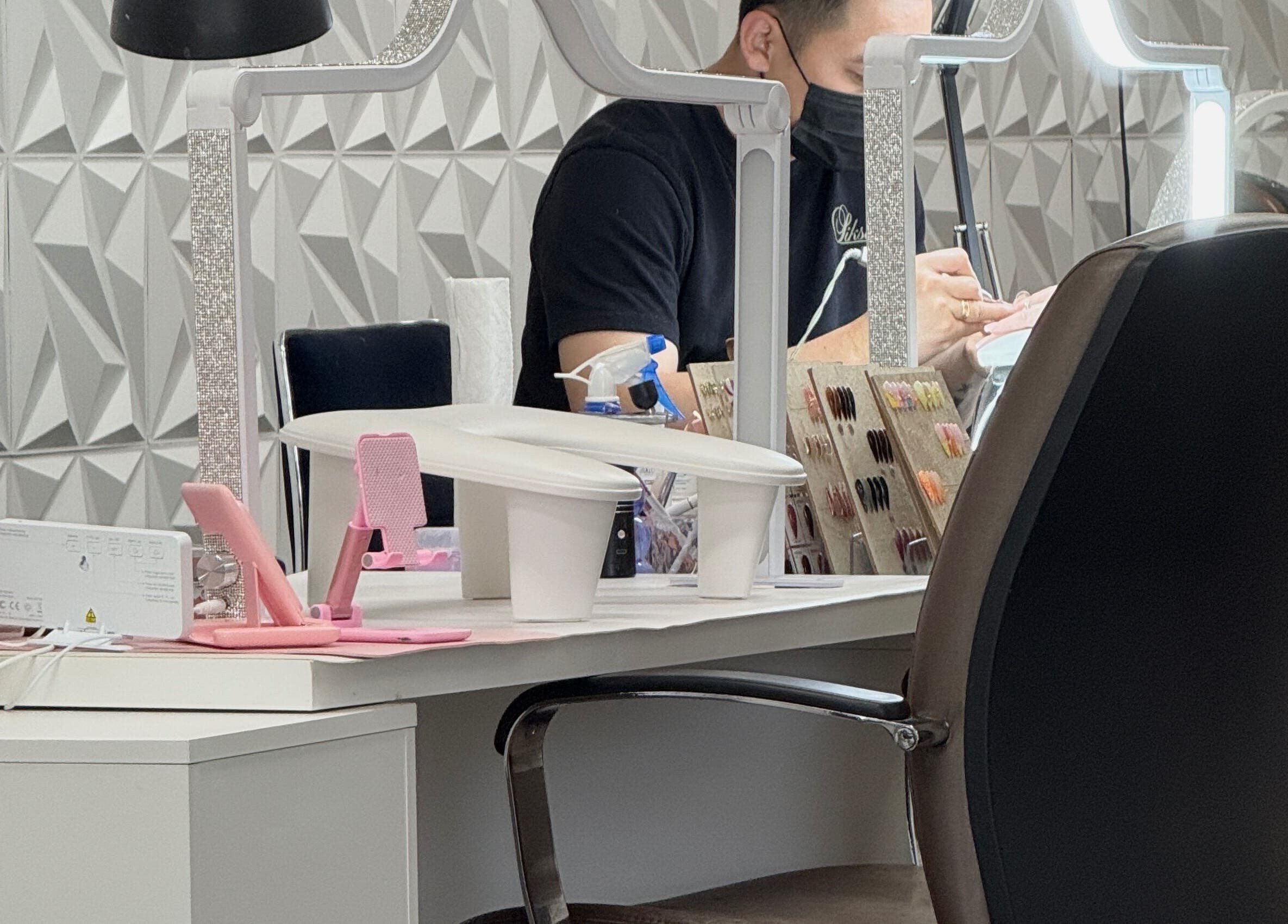 Nail technician working at MY NAILS in Victoria, Texas, US, with tools and polish display.