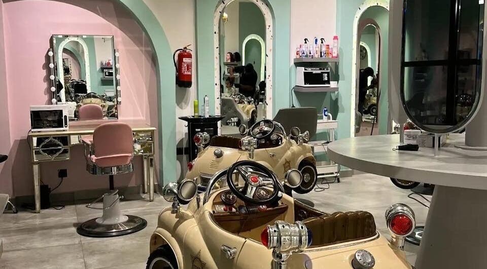 صالون للأطفال في Cheek Dimple، الرياض، الرياض بنوافذ كبيرة وكراسي وردية.