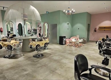 صالون أطفال مرح في تشيك ديمبل، الرياض، الرياض بروفنس، يتميز بديكورات ملونة وكراسي على شكل سيارة.