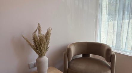 Inviting seating area at Lauren Willett Bespoke Hair the Loft, Bexhill, England, GB. Cozy chair and vase.