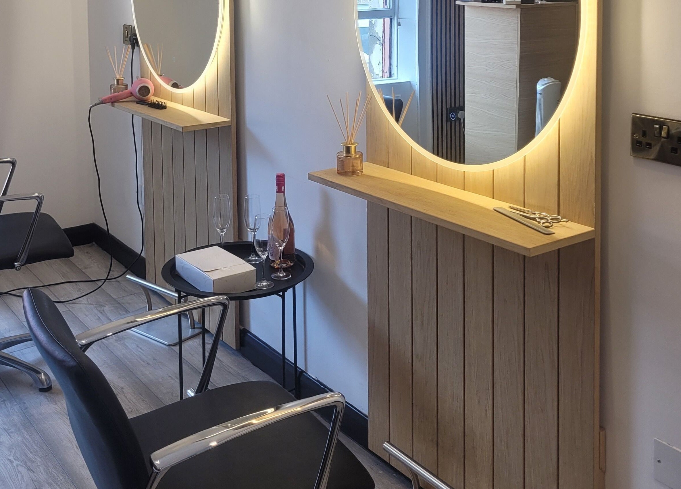Modern styling station at The Hair Room, Dublin, County Dublin, IE, featuring sleek chairs and a lit mirror.