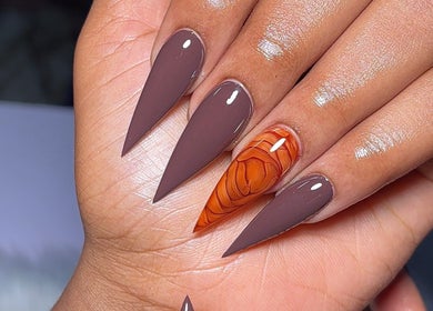 Stylish almond-shaped nails with brown and orange marble designs at SAUCE NAILS, Lagos, Lagos, NG.