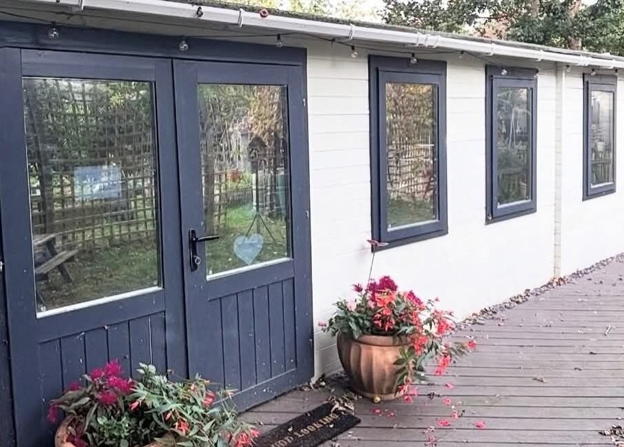 Charming entrance at Aimez Vous, Marks Tey, England, GB, surrounded by greenery and vibrant flowers.