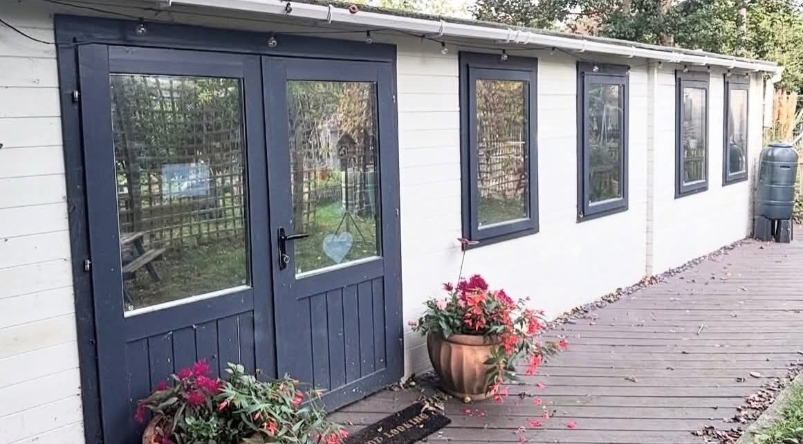 Charming entrance at Aimez Vous, Marks Tey, England, GB, surrounded by greenery and vibrant flowers.