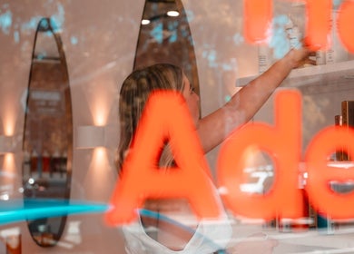 Person reaches for hair products at HairyAdelaide, Mona Vale, New South Wales, AU, showcasing vibrant salon atmosphere.