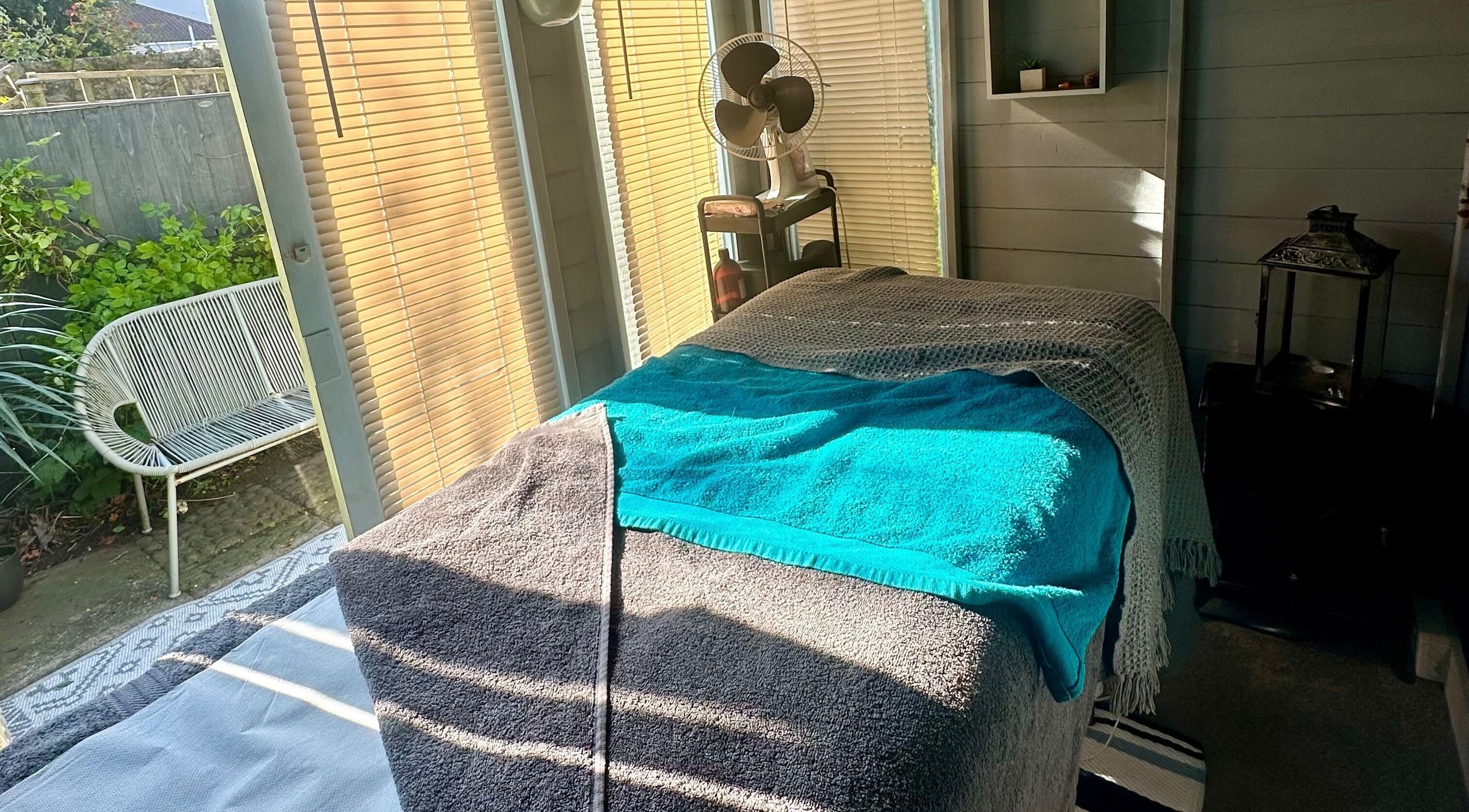 Serenity Massage Therapies Axbridge's cozy massage room with sunlit decor in Axbridge, England, GB.