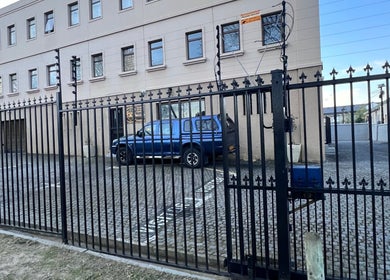 CC Euphoria's secure gated entrance in Cape Town, ZA, showcasing elegant architecture and parking space.
