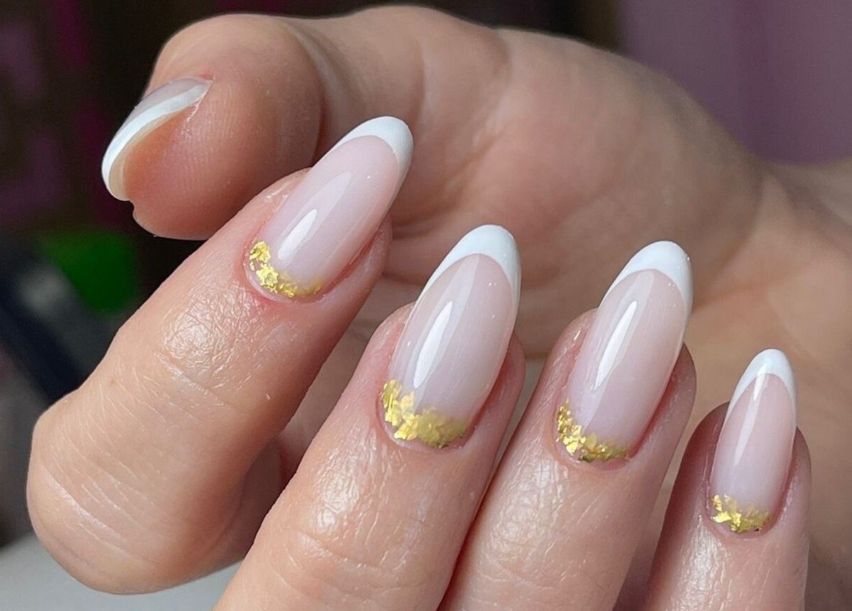 Elegant French manicure with gold accents at Hello Dolly Beauty Center, Doha, Doha Municipality, QA.